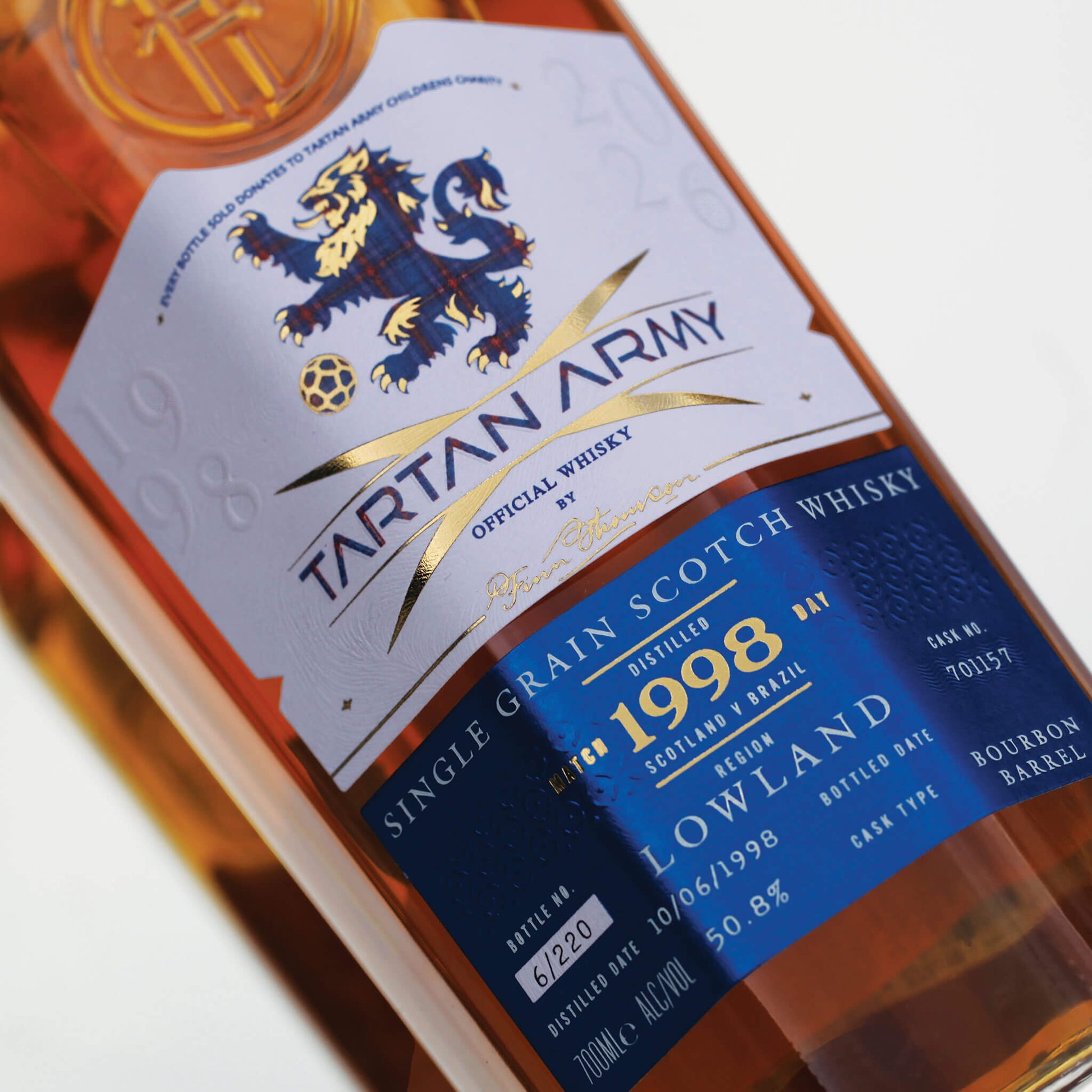 Close up image of bottle of Tartan Army Lowland Whisky on grey background