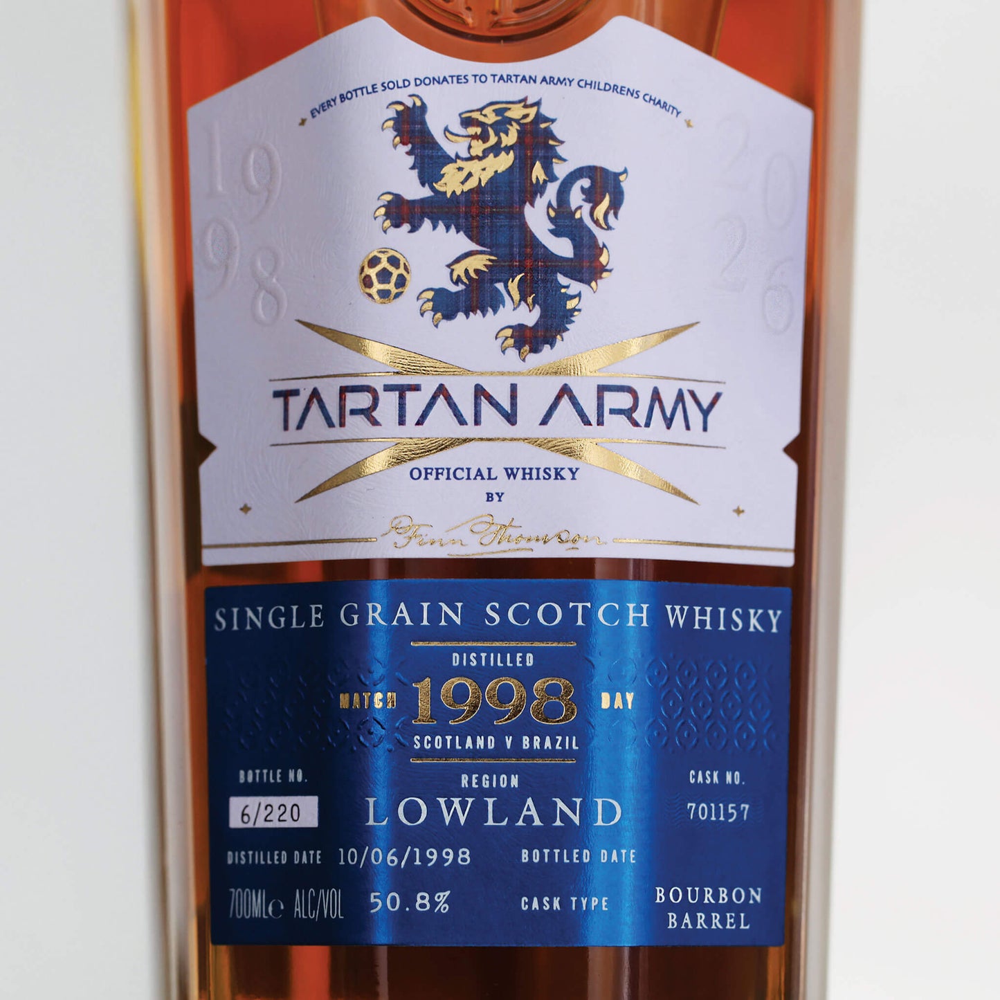 Close up image of bottle of Tartan Army Lowland Whisky on grey background